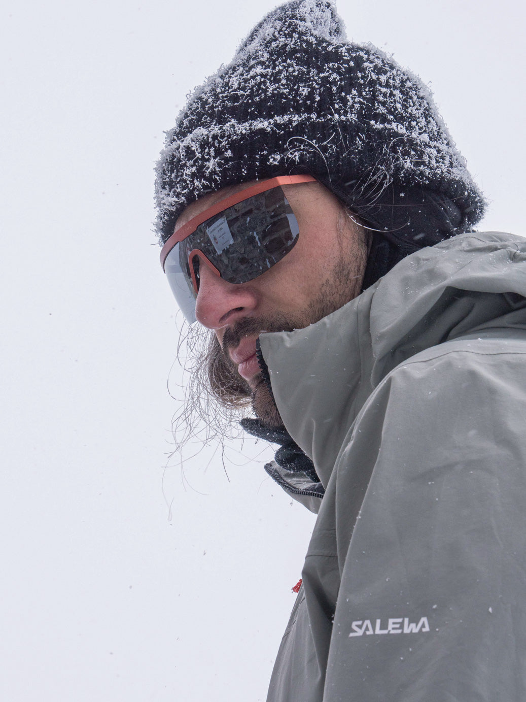 a guy wearing glacier sunglasses with a cloudy background
