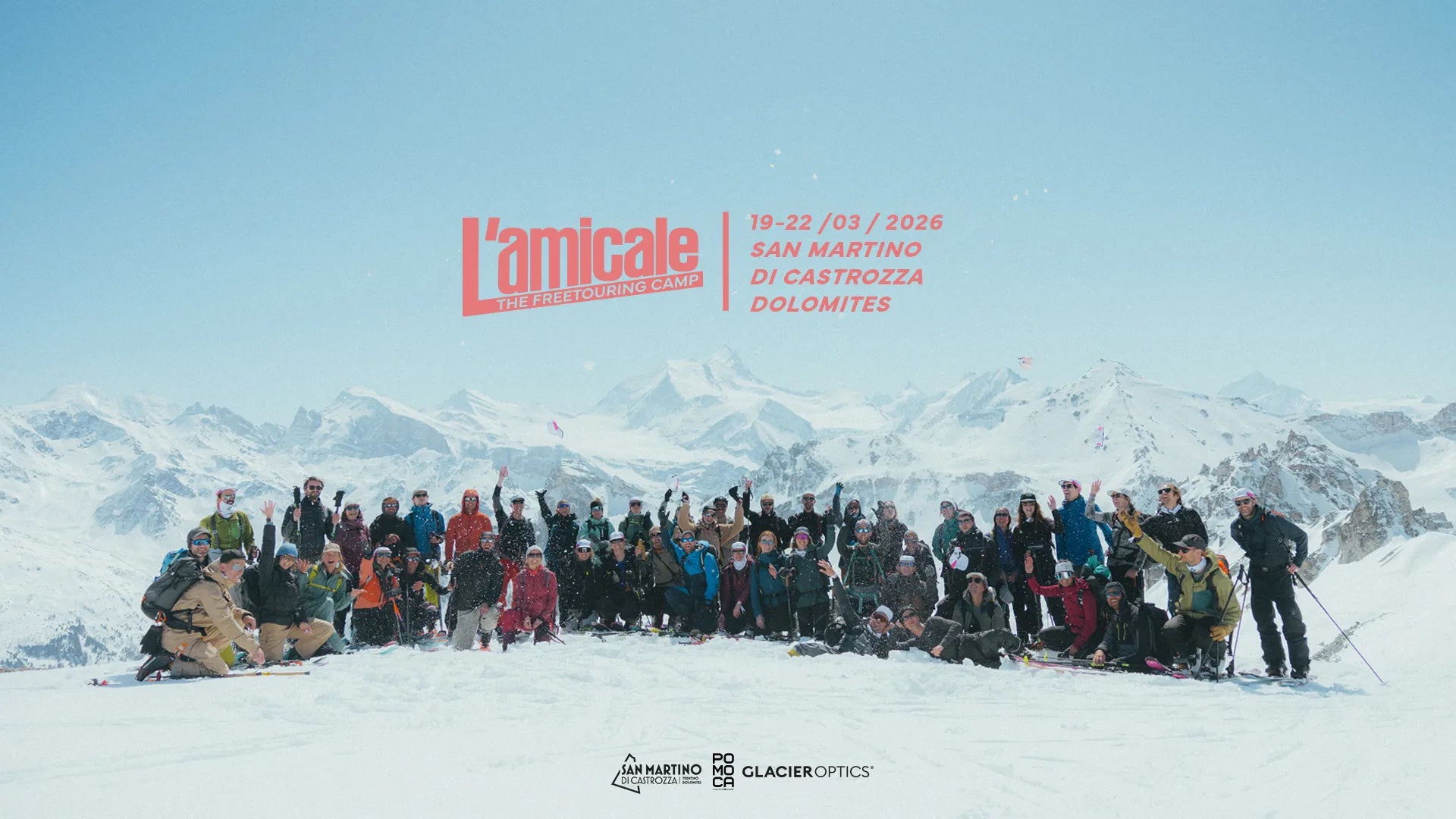 Young man walking on a snowy mountain with his alpinist and ski materials, snowy mountains and his friend in the background