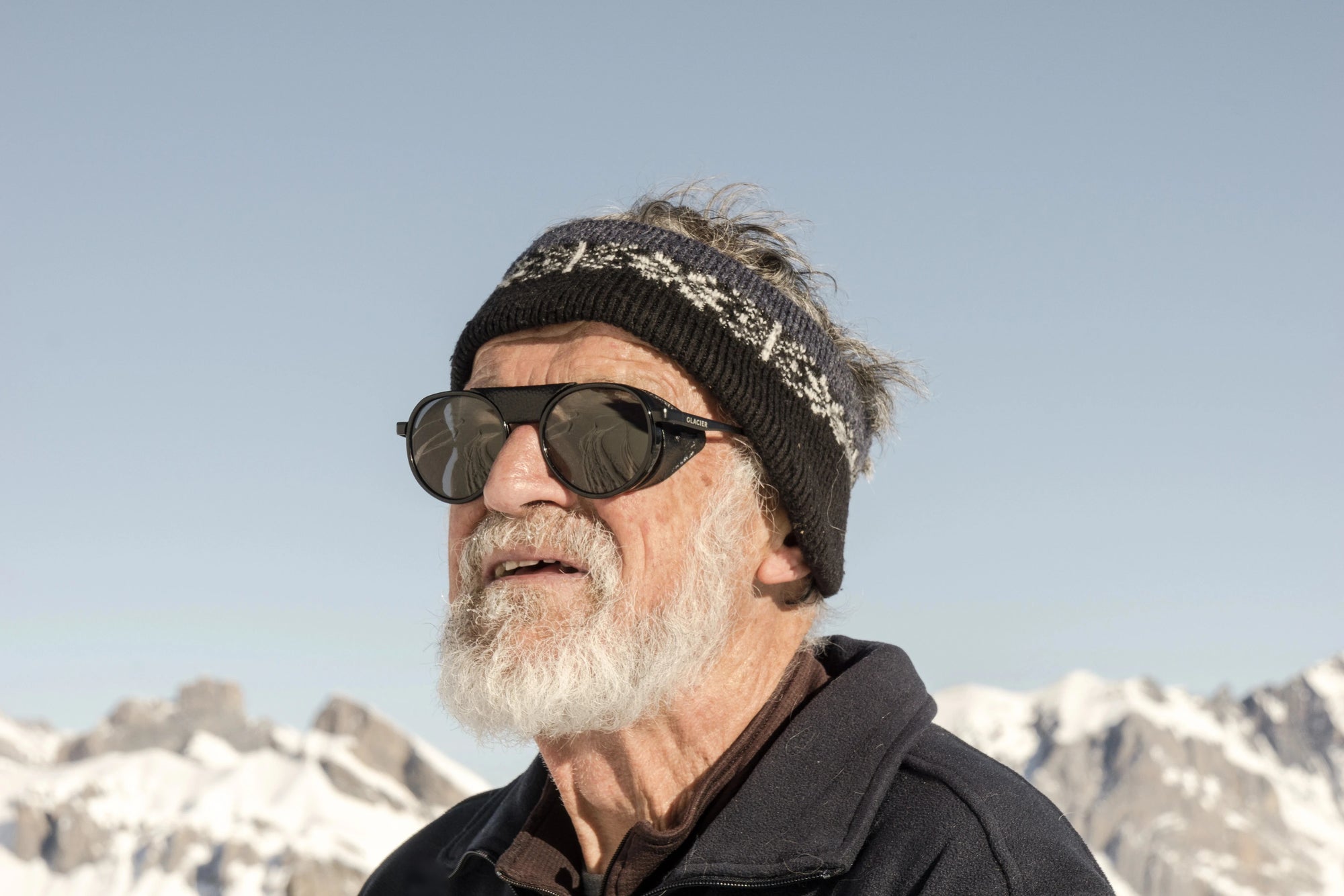 Roland wearing Moiry black sunglasses  with mountains in the background