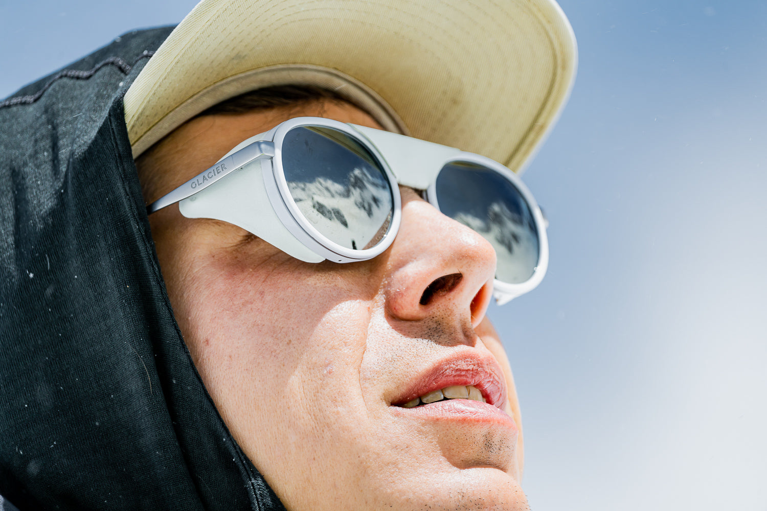 Guy with white sunglasses with wind shields looking at the sun