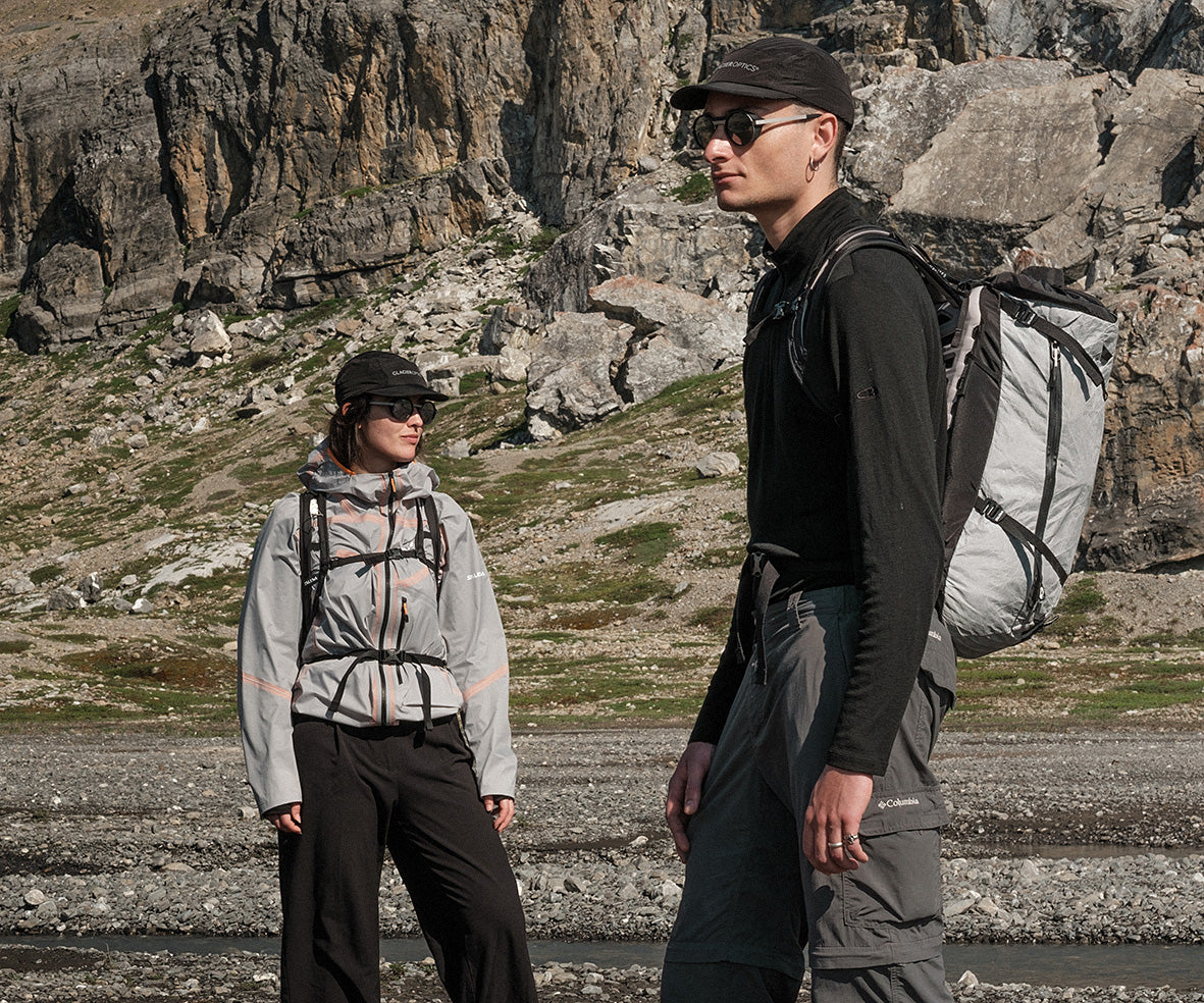 a guy and a woman wearing glacier sunglasses with a mountain background, hike mood